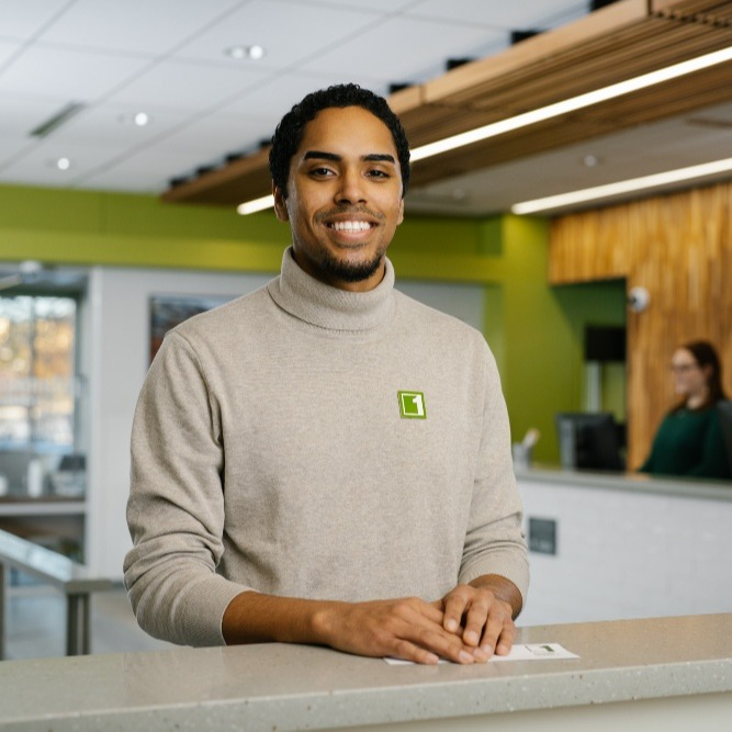 CU1 employee standing at the teller line, smiling